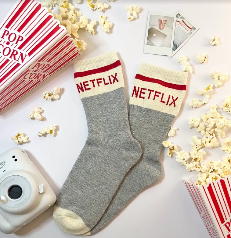 Netflix socks surrounded by popcorn.